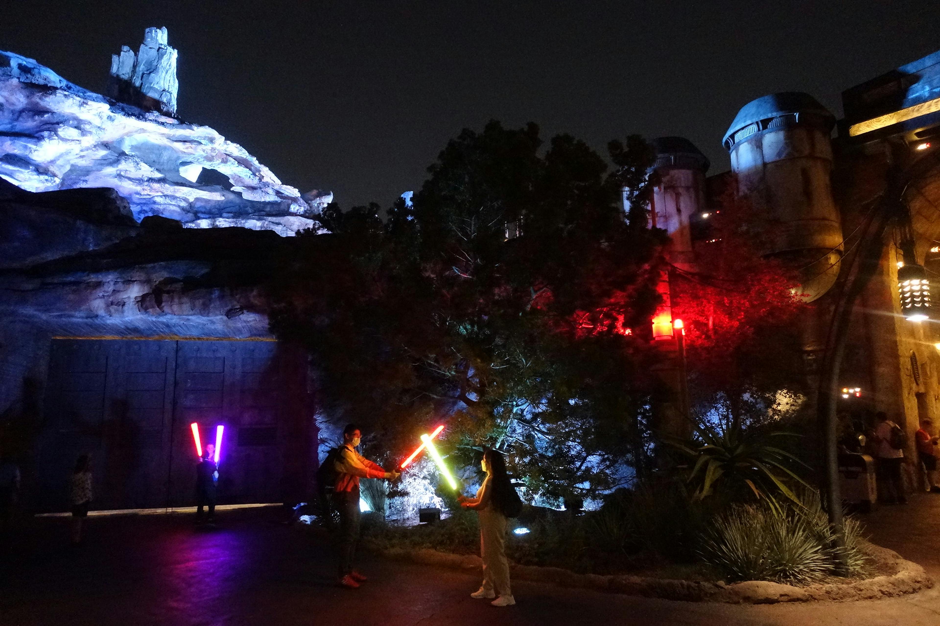 Park visitors wielding lightsabers in Star Wars: Edge of the Galaxy