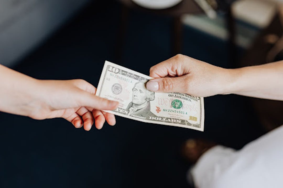 Source: https://www.pexels.com/photo/hands-holding-a-10-dollar-bill-4968382/