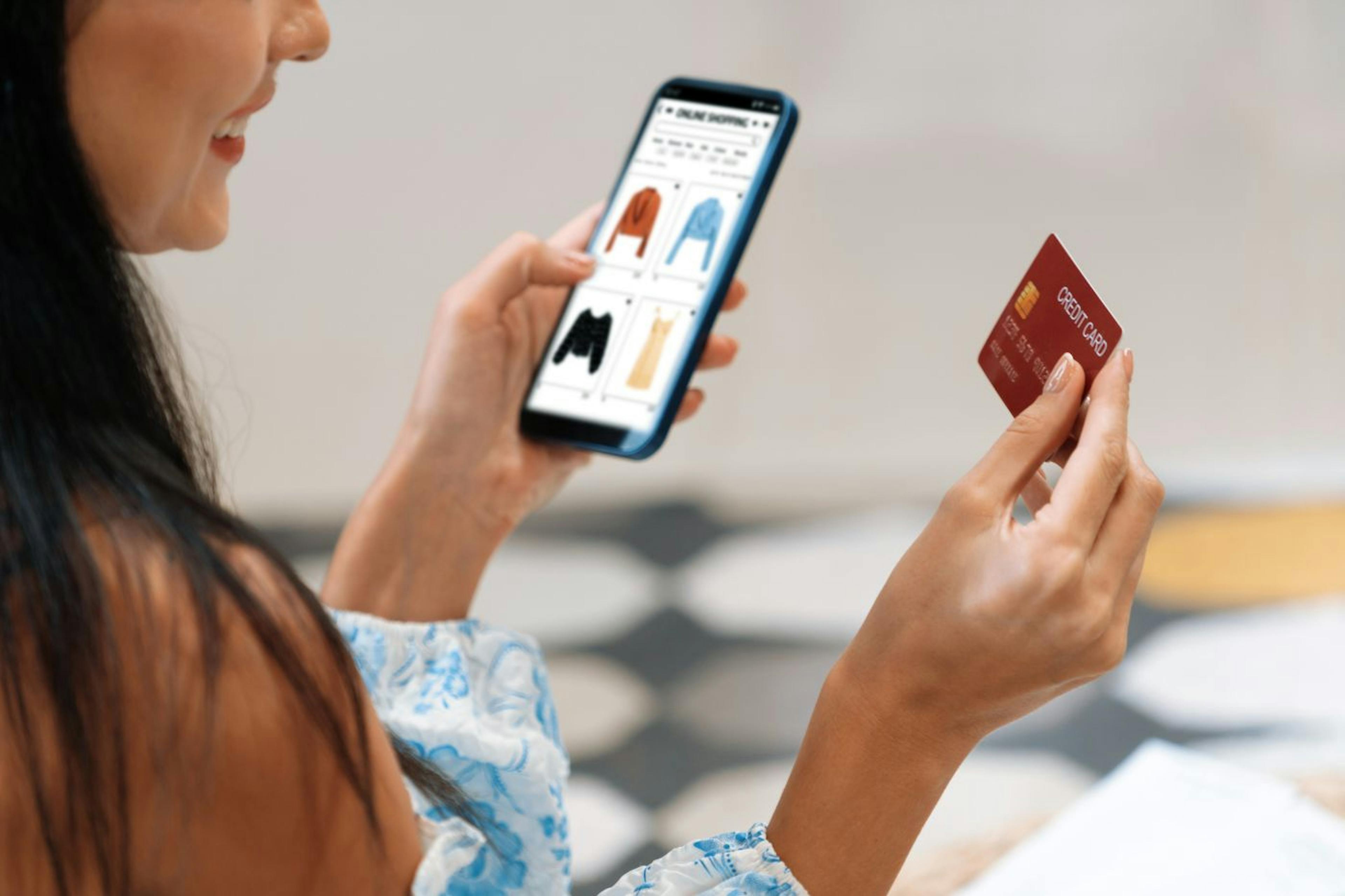 A customer browsing clothing options on her phone, ready to make an online purchase.