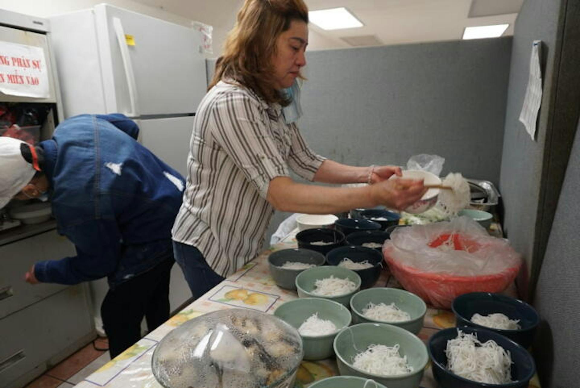 Caption: Duyen Hoang preparing food for the Saturday-morning group. Credit:Lam Thuy Vo/The Markup