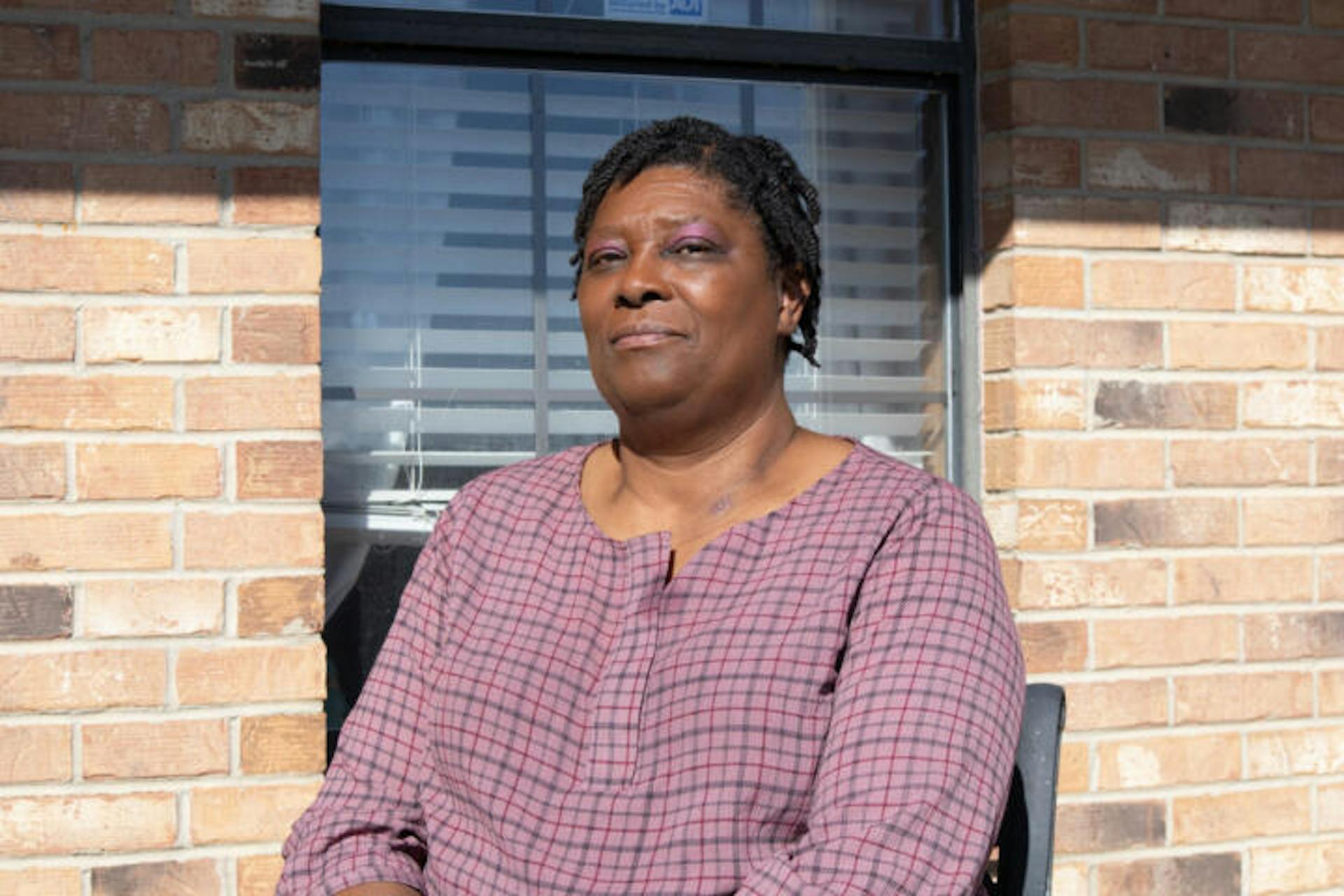 Evelyn Washington, a native of Rome, Mississippi, sits outside her home on an early morning in November. Credit: Charles Coleman