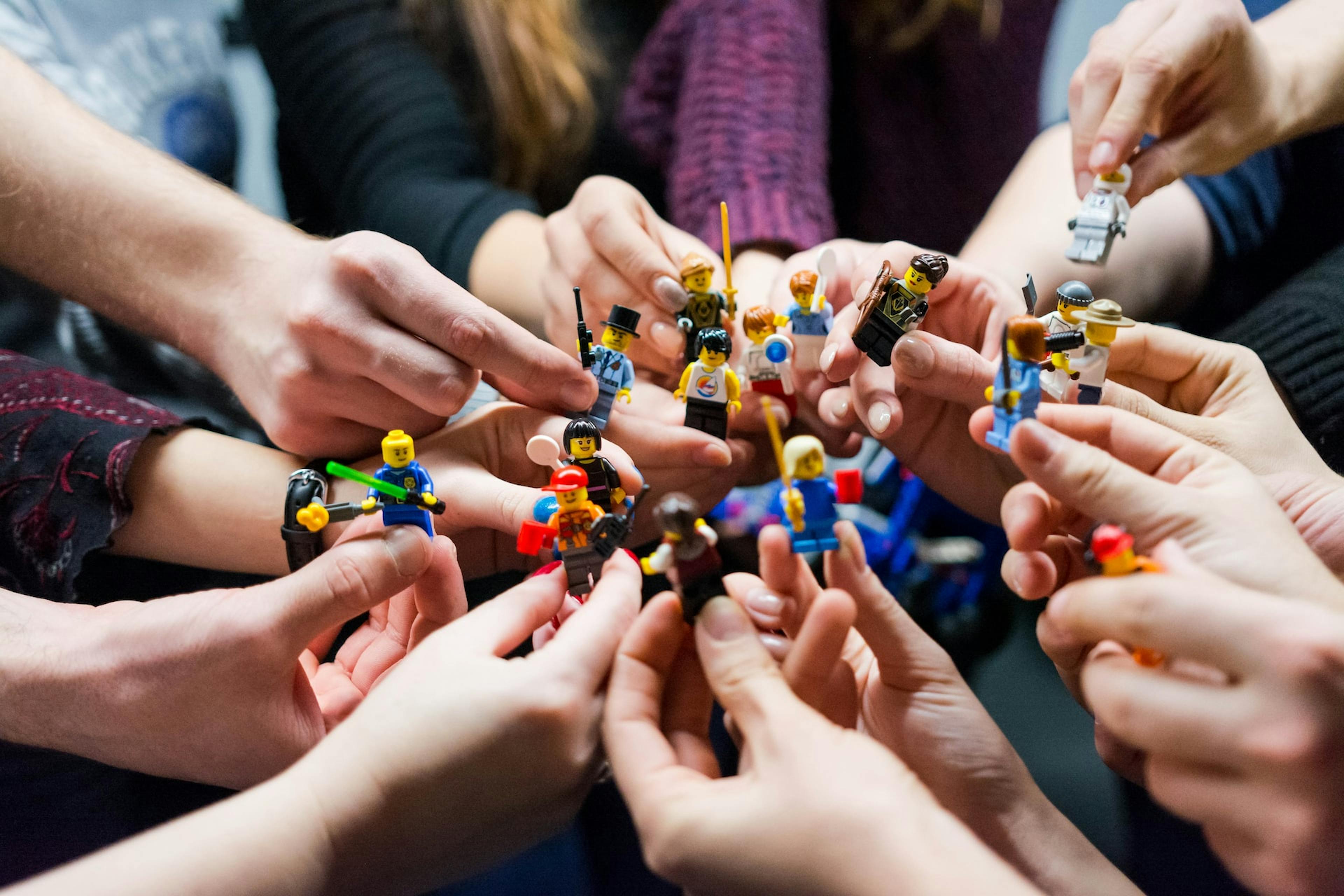 Equipe de pessoas, segurando lego figos juntos