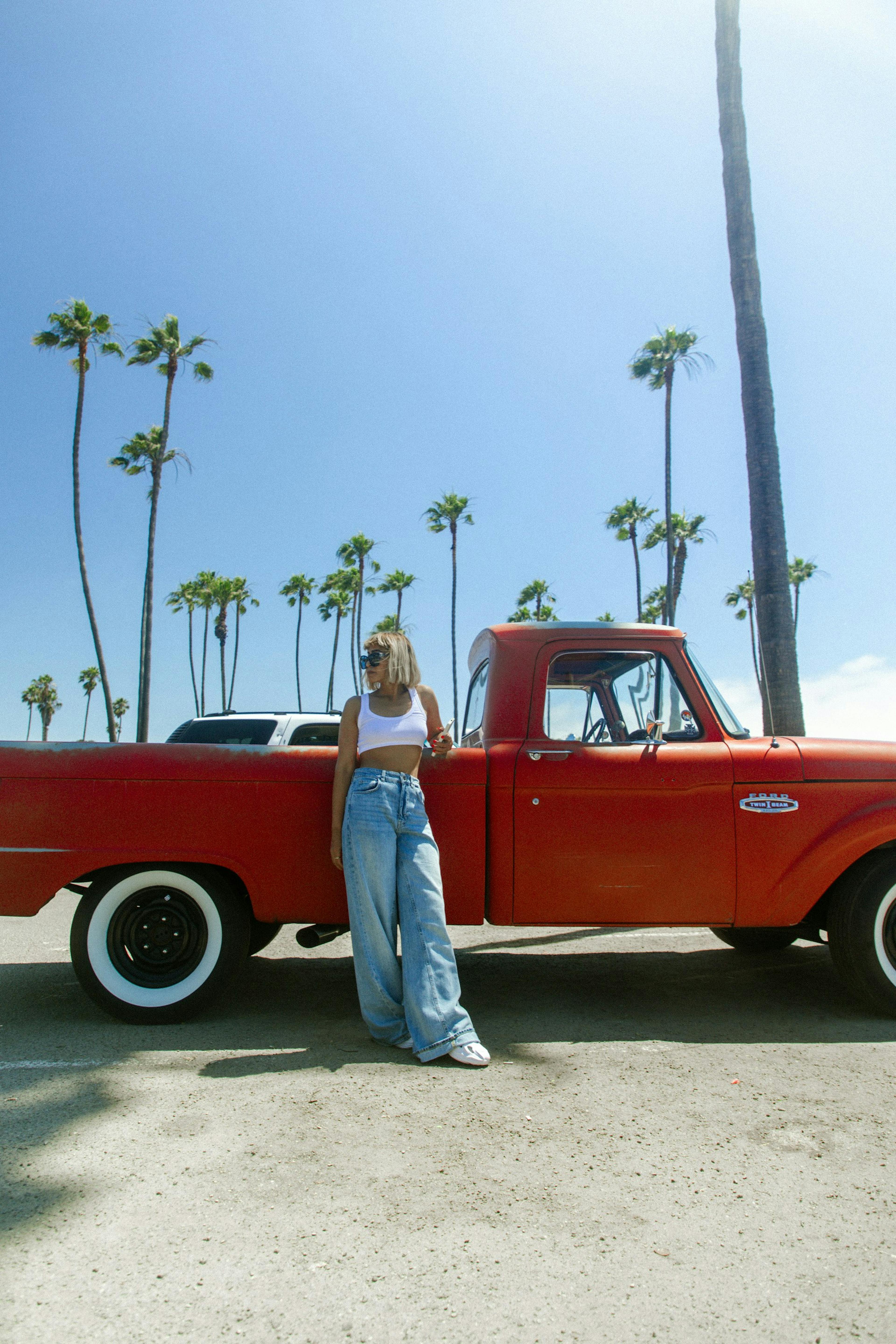 a woman standing next to a red truck - Photo by Pawan Thapa / Unsplash