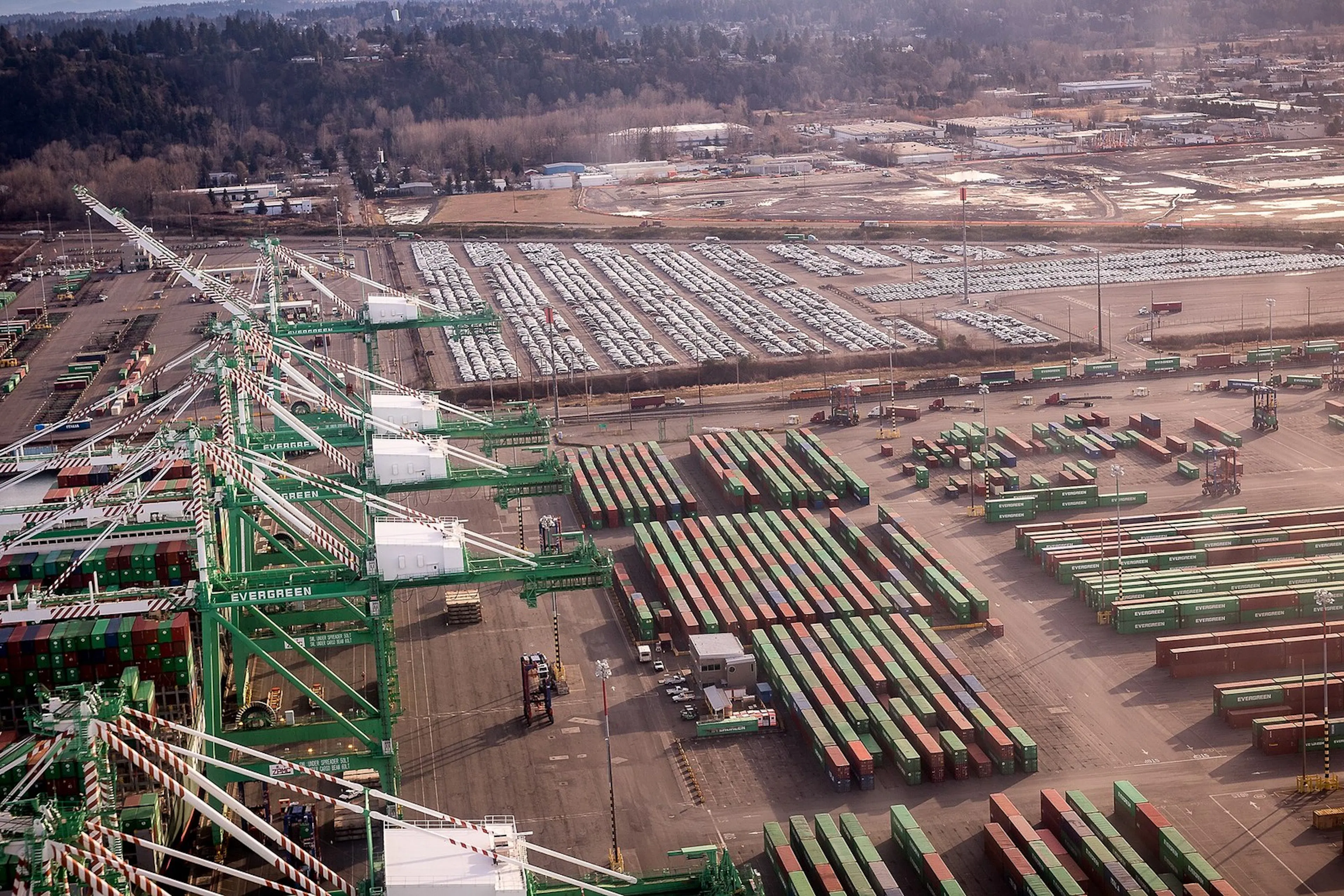 Aerial view of a container terminal stacked with shipping containers and gantry cranes