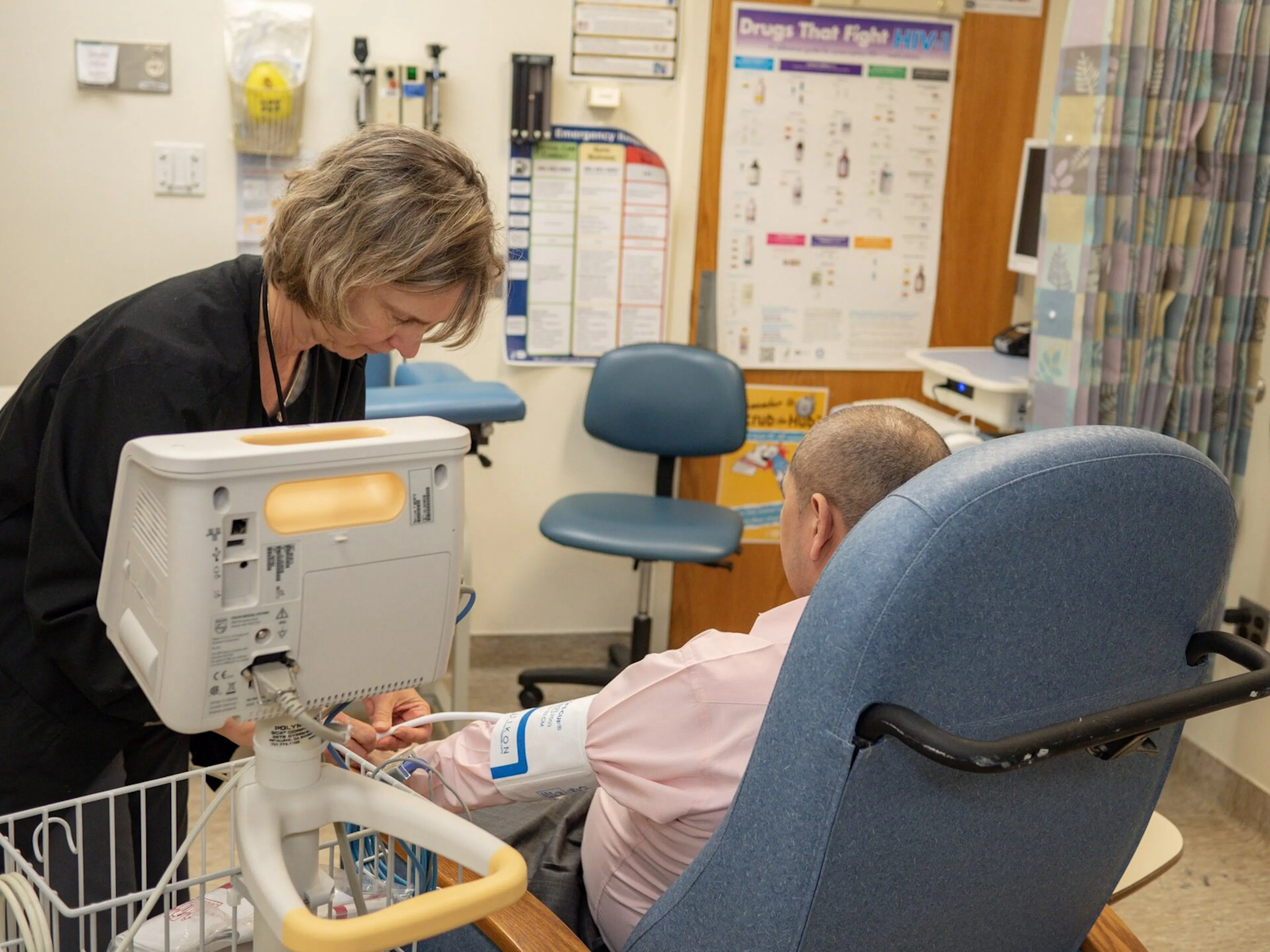 A nurse taking vital signs from a volunteer enrolled in a clinical trial