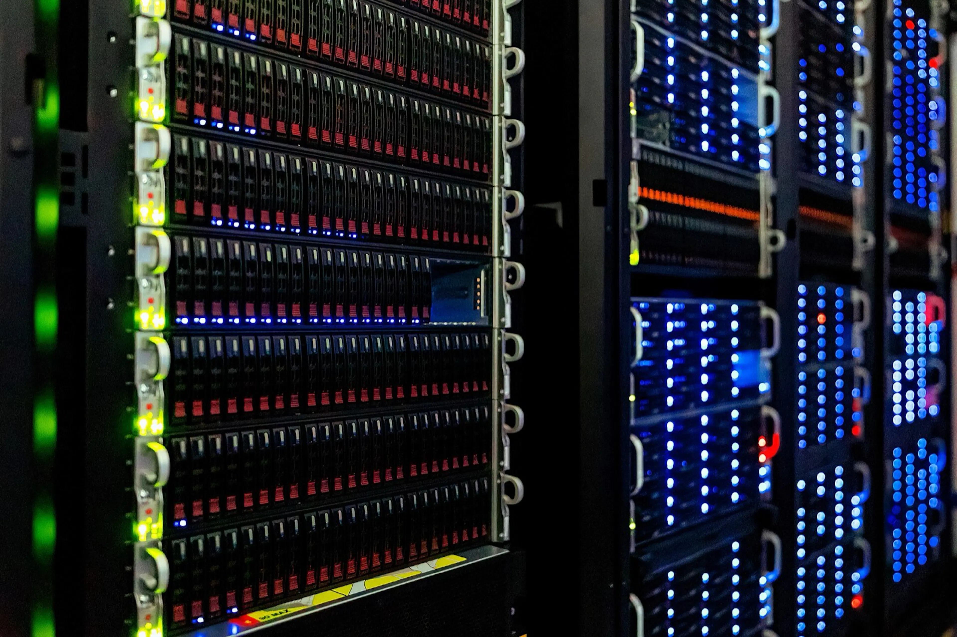 Racks in a dark server room. The device model beneath KVM and Xen, the hypervisors of the open-source cloud, descends from an emulator written in 2003.