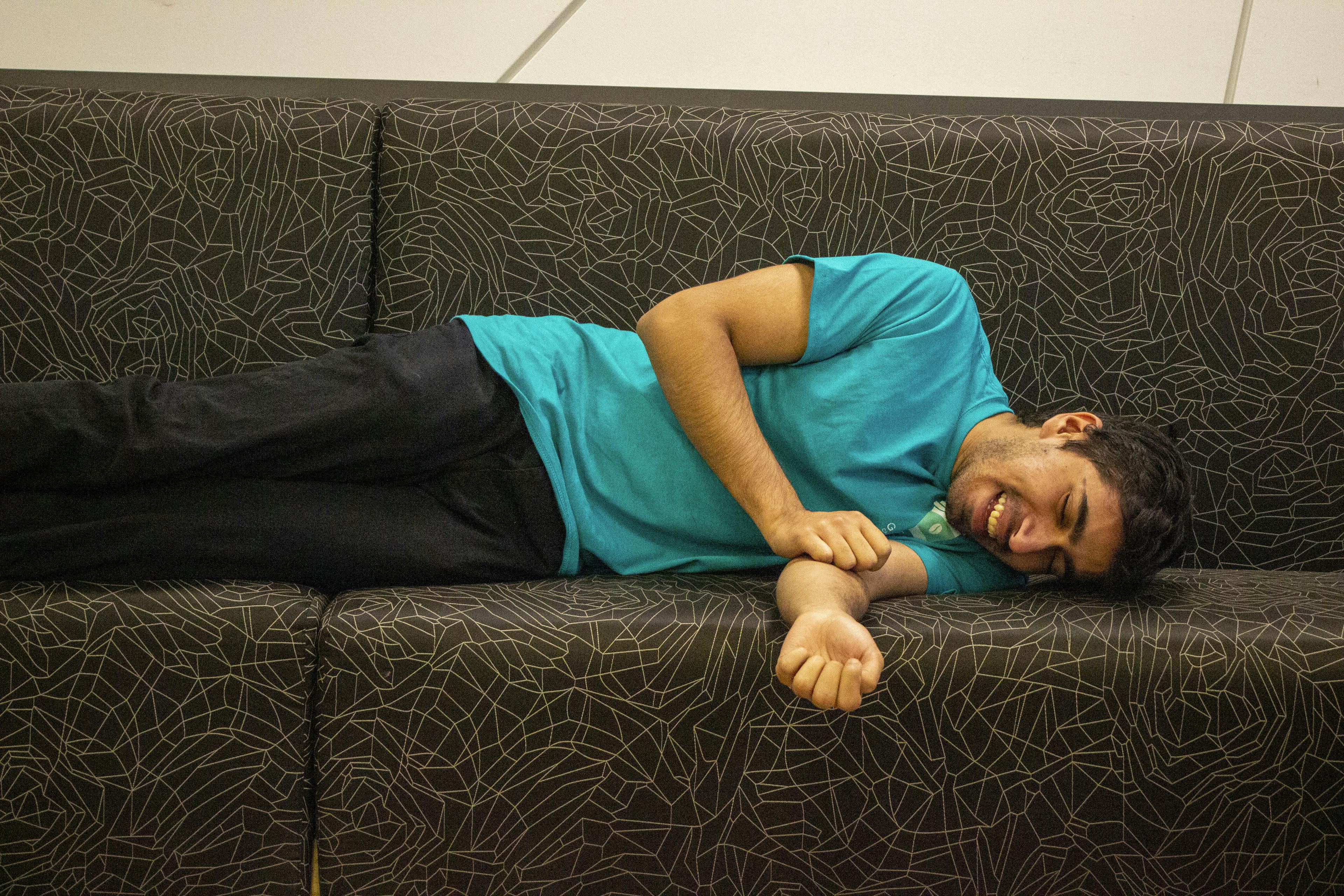 Daniyal laughing on a couch in their office space located at York University.