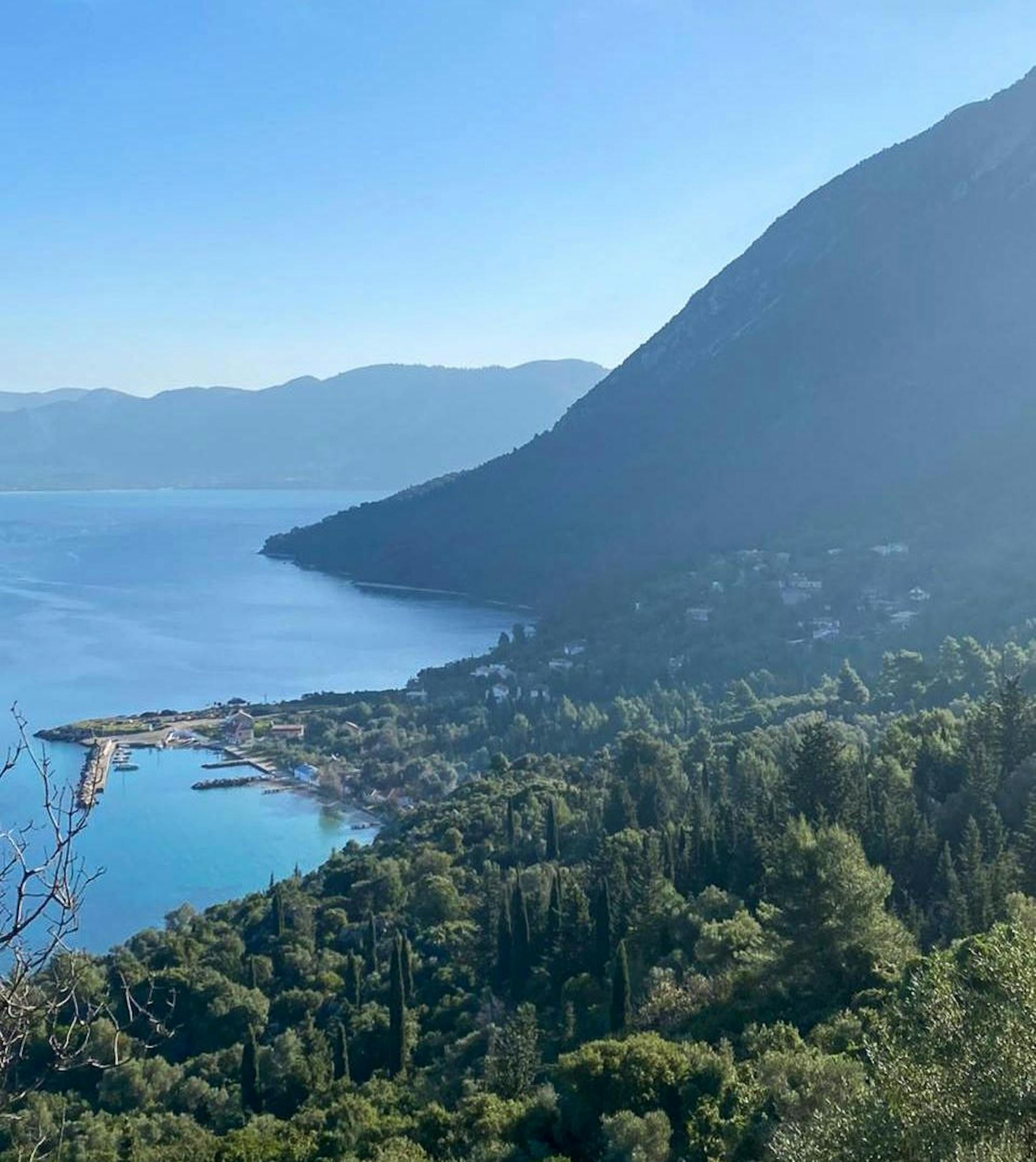 A view from above of Episkopi Village in the northern part of Kalamos Island captures the peaceful charm of the area. Traditional stone houses are scattered throughout, olive trees and Mediterranean vegetation dot the landscape, while fishing boats line the port.