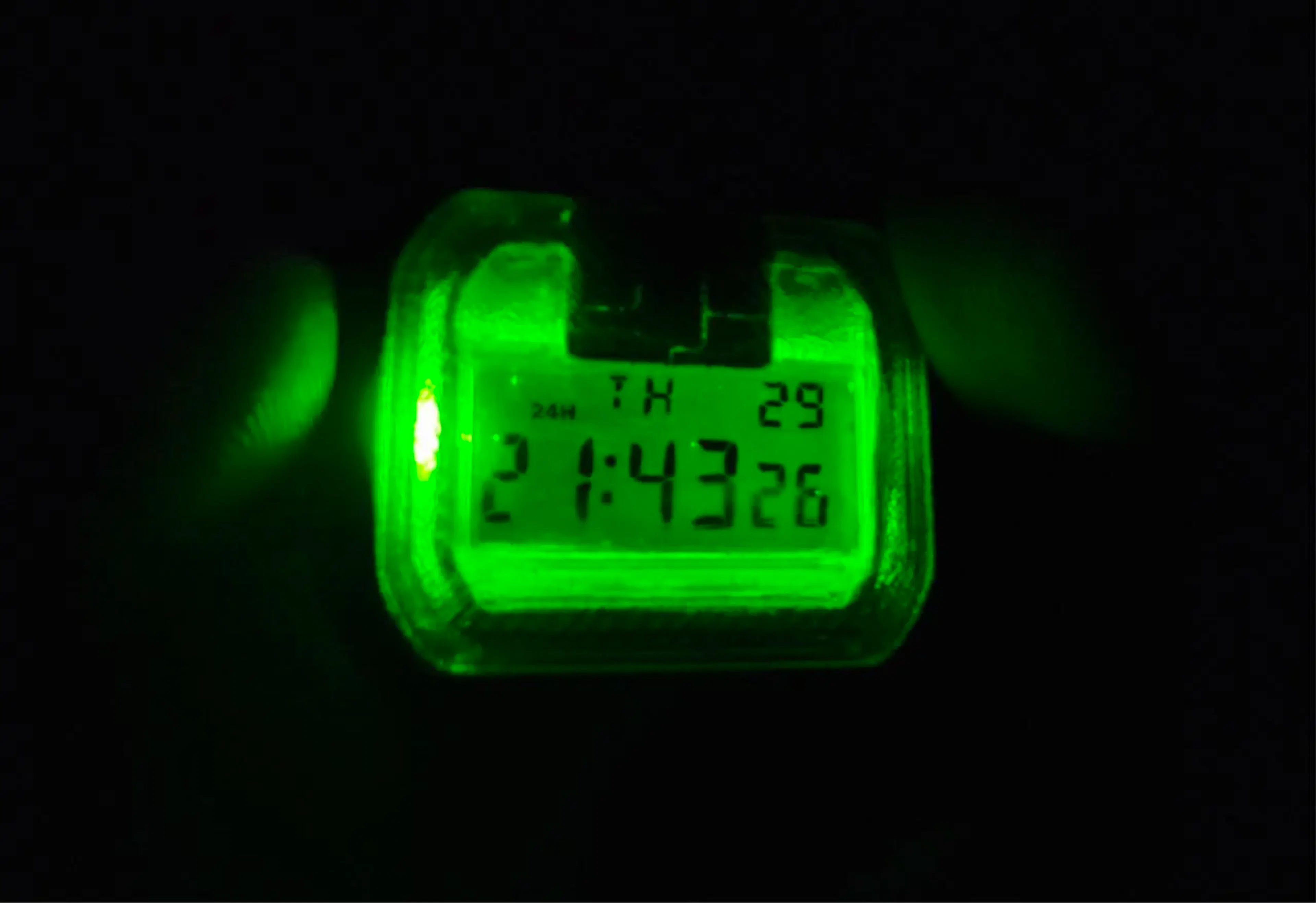 Night view of the CASIO F-91W digital watch — kryptonite-green led backlight