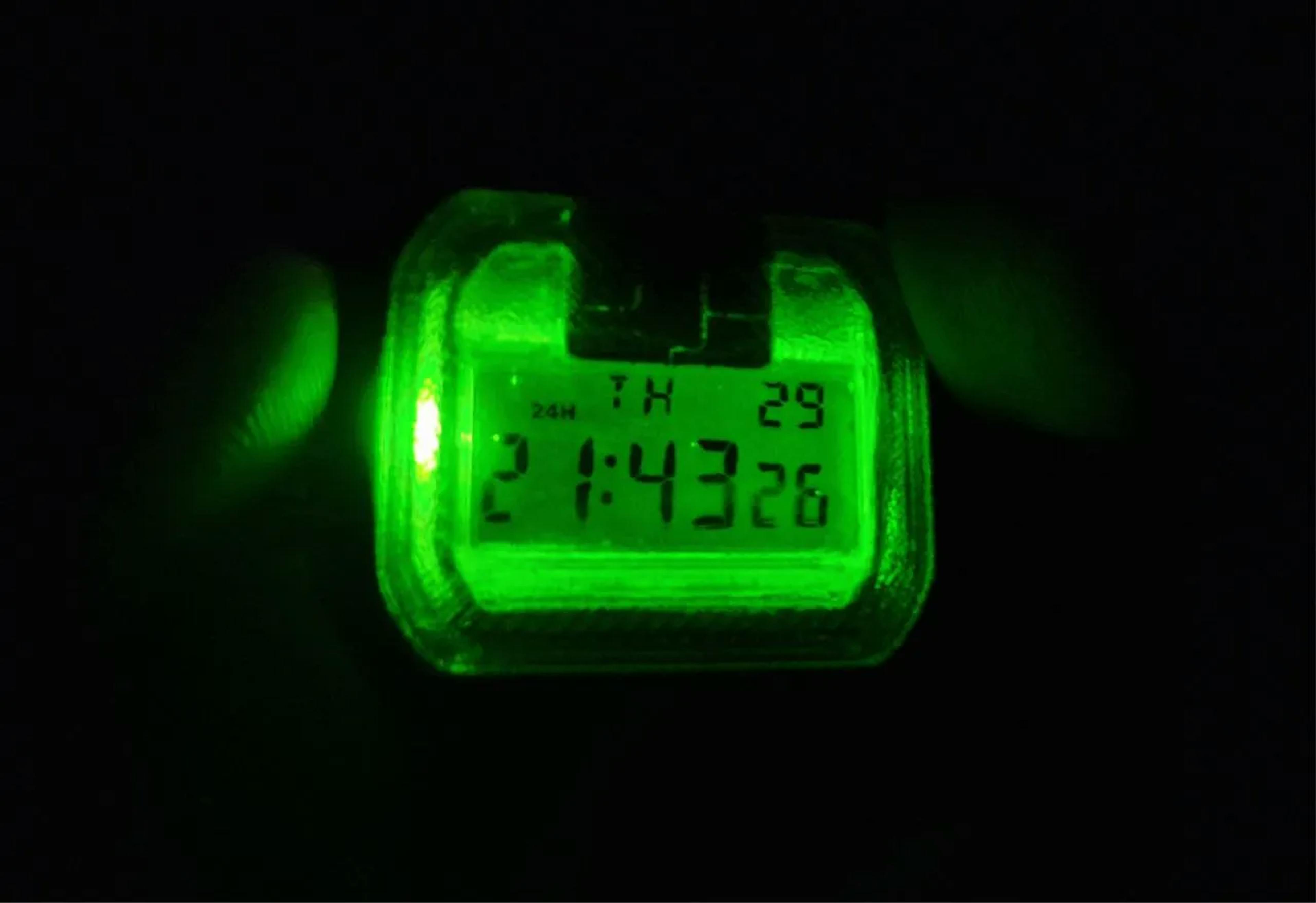 Night view of the CASIO F-91W digital watch — kryptonite-green led backlight