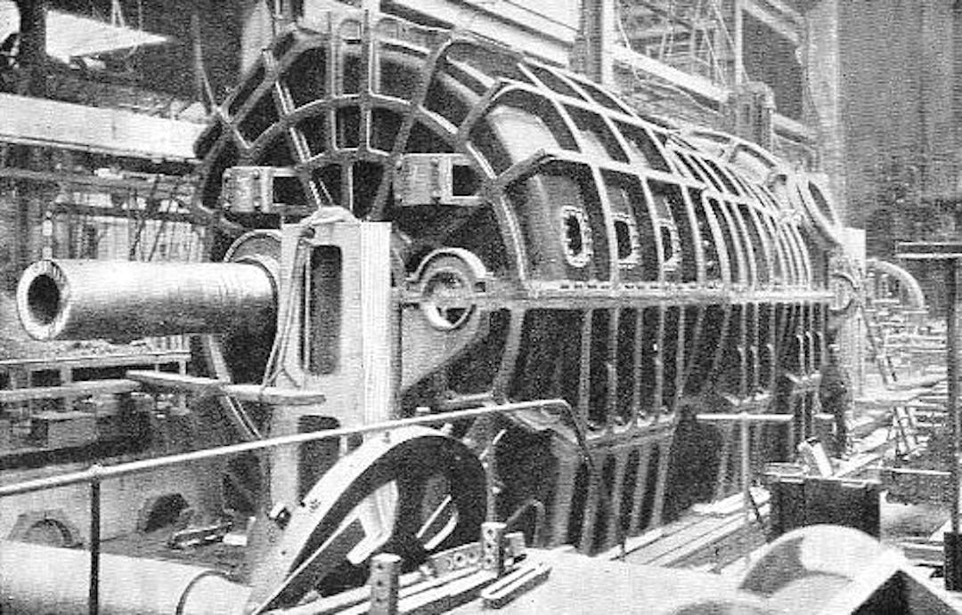 One of the low-pressure turbines of the Carmania, in casing. Its size will be inferred from comparison with the man standing near the end of the casing.